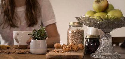 green apple fruit beside clear glass jar on brown wooden table