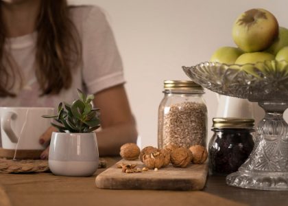green apple fruit beside clear glass jar on brown wooden table
