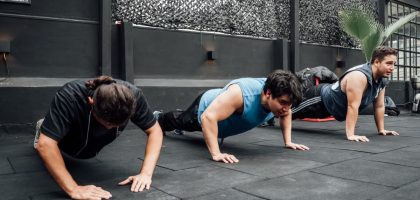 Men performing push-ups during a group workout session in Mexico City gym.