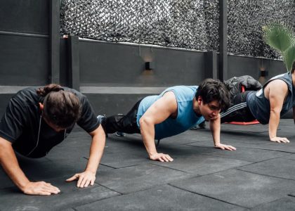 Men performing push-ups during a group workout session in Mexico City gym.